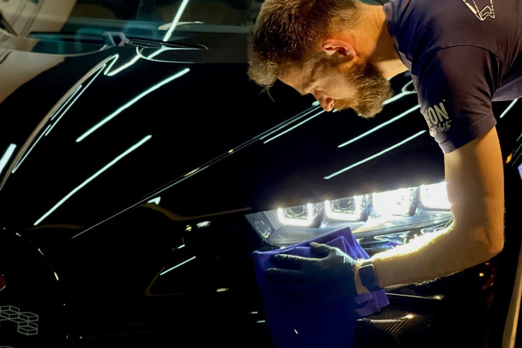 detailer die bezig is om een auto te poetsen