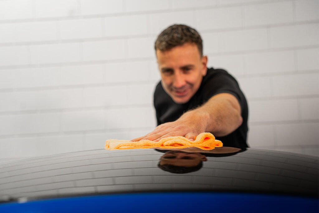 man die lak aan het uitbuffen is van keramische coating